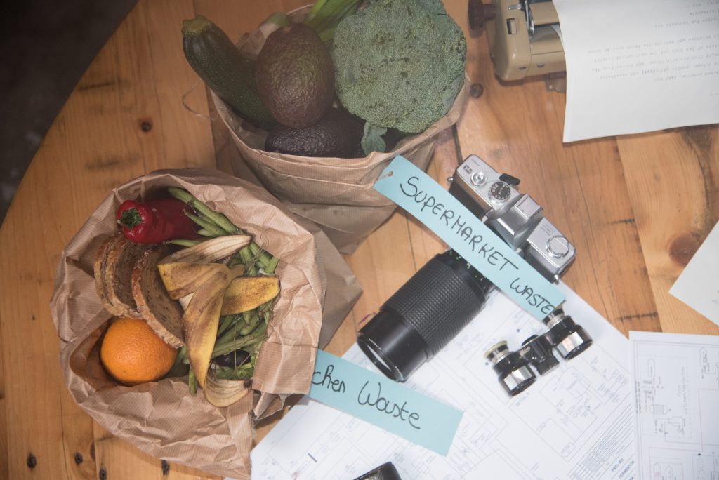 Picture showing food waste (kitchen waste and supermarket waste) in paper bags and two old cameras