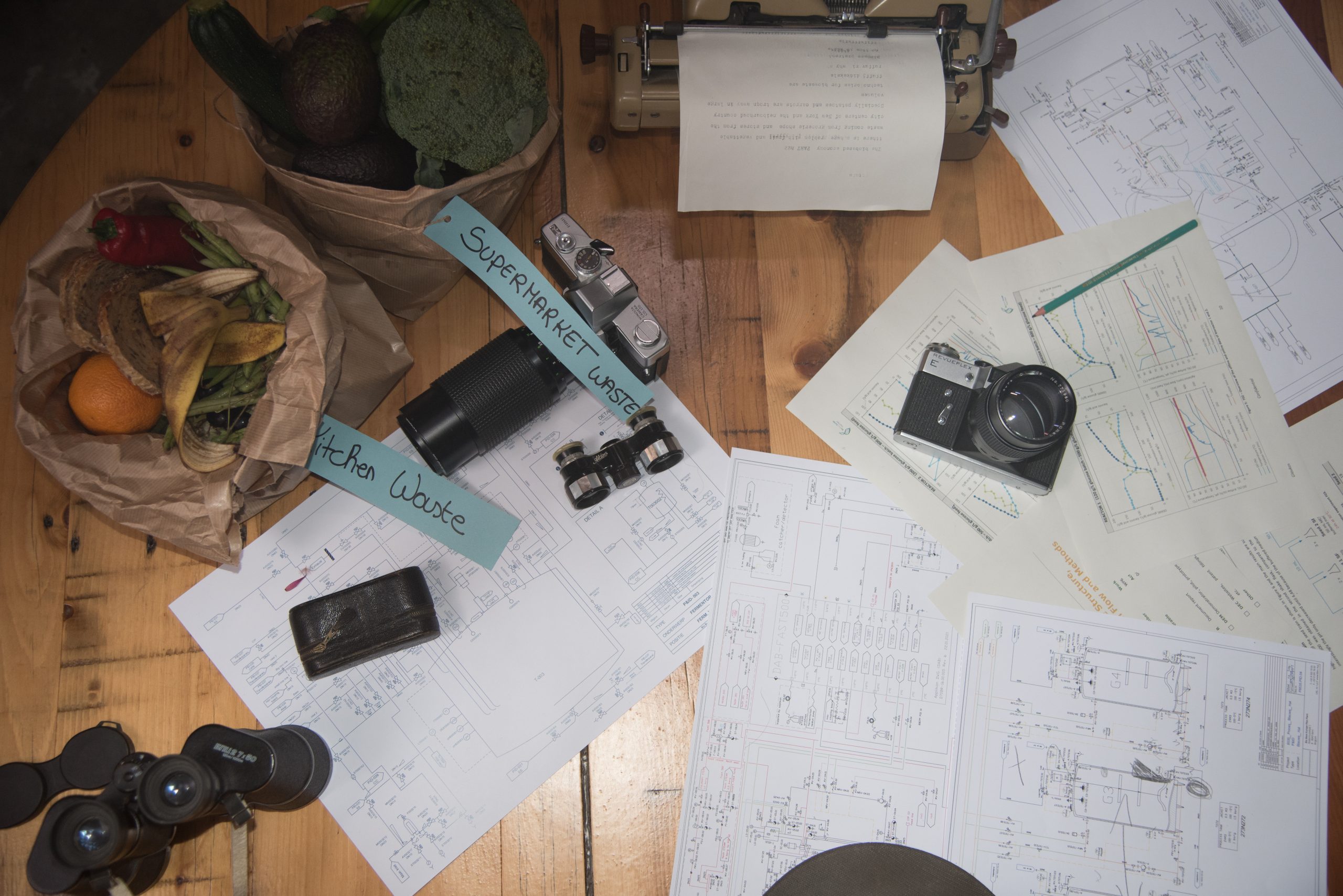 Picture showing cameras, biowaste, binoculars, typewriter and biotechnology processing data sheets, Tech4Biowaste Background